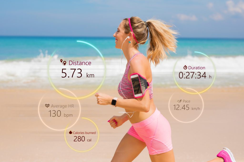 An athlete wearing a smartwatch displaying heart rate and activity metrics during a run, highlighting the use of wearable technology for fitness monitoring